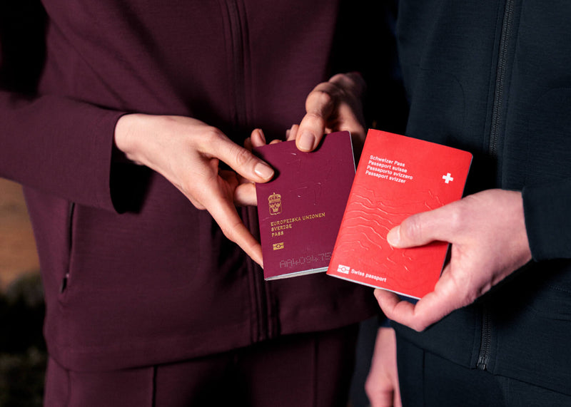 Two people holding passports with a blurred background